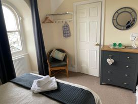 A bedroom with a bed and dresser at Noddfa Country House in Harlech