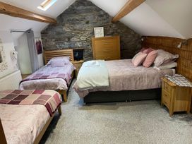 A bedroom with two beds and furniture at Noddfa Country House Harlech