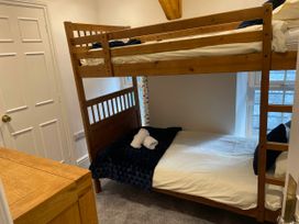 A bunk bed and a single bed in a bedroom at Noddfa Country House in Harlech