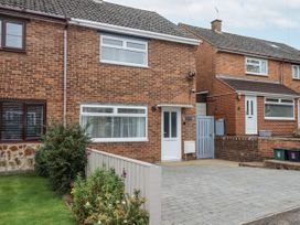 A brick house with a driveway and garden at Milana in Tiverton