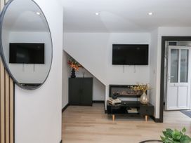 A living room with a television and furniture at Milana in Tiverton