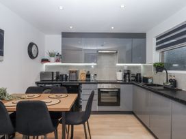 A kitchen with appliances and dining table at Milana in Tiverton