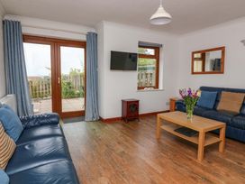 A living room with a sofa and a table at Surf View in Hope Cove