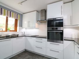 A kitchen with cabinets, oven, and a sink at Surf View in Hope Cove