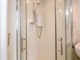 A shower area with controls and glass door at Surf View in Hope Cove