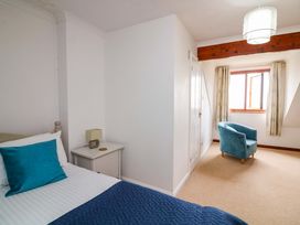 A bedroom with a bed and chair at Surf View in Hope Cove