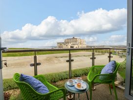 A balcony with green chairs and a small table at Penthouse @46Zinc - Headland View in Newquay