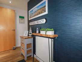 A hallway with a wooden shelf and sign at Penthouse @46Zinc - Headland View, Newquay