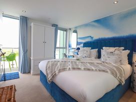 A bedroom with a bed and wardrobe at Penthouse @46Zinc - Headland View, Newquay