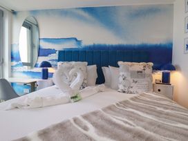 A bedroom with a bed and decorative pillows at Penthouse @46Zinc - Headland View in Newquay