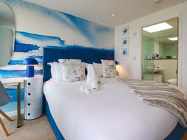 A bedroom with a double bed and attached bathroom at Penthouse @46Zinc - Headland View, Newquay