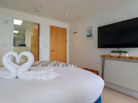 A bedroom with a bed and television at Penthouse @46Zinc - Headland View, Newquay