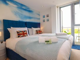A bedroom with two beds and a balcony at Penthouse @46Zinc - Headland View, Newquay