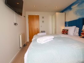 A bedroom with a bed and television at Penthouse @46Zinc - Headland View, Newquay
