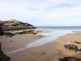 A beach with rocky formations and buildings in the background at Penthouse @46Zinc - Headland View, Newquay
