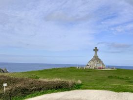 A cross monument on a grassy area overlooking the ocean at Penthouse @46Zinc - Headland View, Newquay