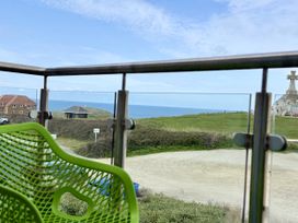 A balcony view overlooking the sea and grass at Penthouse @46Zinc - Headland View in Newquay