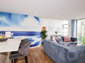 A living room with a blue wall and fruit bowl at Penthouse @46Zinc - Headland View Newquay