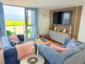 A living room with a sofa and television at Penthouse @46Zinc - Headland View, Newquay