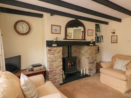 A living room with a fireplace and sofa at 1 The Square in Hope Cove