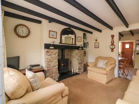 A living room with a fireplace and seating area at 1 The Square Hope Cove