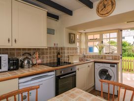 A kitchen with appliances including a kettle and washing machine at 1 The Square, Hope Cove