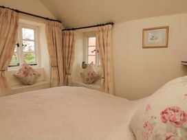 A bedroom with a bed and windows at 1 The Square in Hope Cove