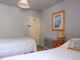 A bedroom with twin beds and a bedside table at 1 The Square Hope Cove