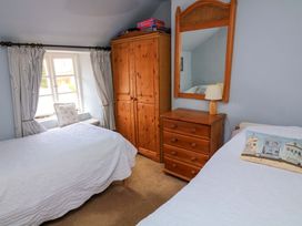 A bedroom with two beds and a wardrobe at 1 The Square in Hope Cove