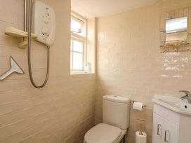 A bathroom with a shower, toilet, and sink at 1 The Square, Hope Cove