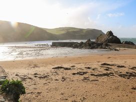 A beach with sand and rocks at 1 The Square Hope Cove
