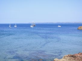 A view of boats on the sea with a rocky shoreline at 1 The Square Hope Cove
