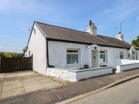 A white single-story house with a tiled roof and small front garden at Cobweb Cottage in Waunfawr