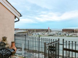 An outdoor view of the shore with a lighthouse at Sammy Hakes Cottage