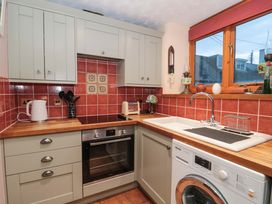 A kitchen with an oven and washing machine at Sammy Hakes Cottage