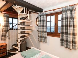 A bedroom with a spiral staircase and window at Sammy Hakes Lookout