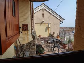 An outdoor area with a bench and chairs at Sammy Hakes Cottage in Watchet
