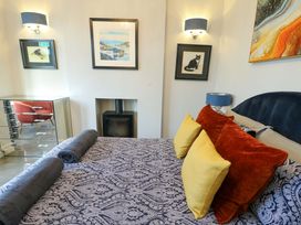 A bedroom with a bed and artworks on the wall at Bronallt Cemaes Bay