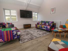 A living room with patterned sofas and a television at St Marys in Penzance