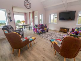 A living room with a sofa, armchairs, and a television at St Marys in Penzance