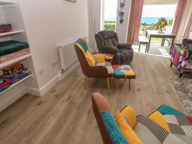 A living room with armchair and dining table at St Marys in Penzance