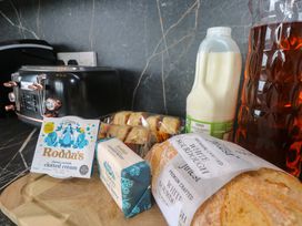 A kitchen counter with a toaster, clotted cream, butter, scones, milk, and iced tea at St Marys in Penzance