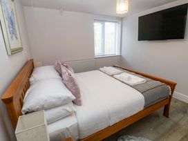 A bedroom with a bed and a TV mounted on the wall at St Marys in Penzance