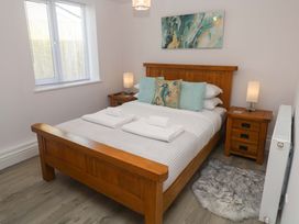 A bedroom with a wooden bed and bedside tables at St Marys in Penzance