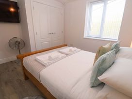 A bedroom with a bed, towels, fan and television at St Marys in Penzance