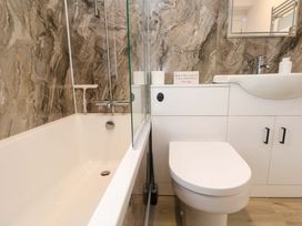 A bathroom featuring a bathtub, toilet, sink, and mirror at St Marys in Penzance