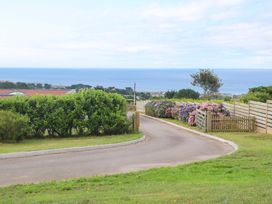 A path leading to the ocean with greenery and flowers at St Marys in Penzance