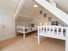 A bedroom with two beds and a wardrobe at St Marys in Germoe