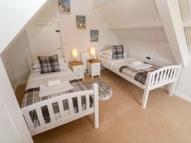 A bedroom with two beds and bedside tables at St Marys in Germoe