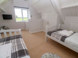 A bedroom with two beds and a television at St Marys in Germoe